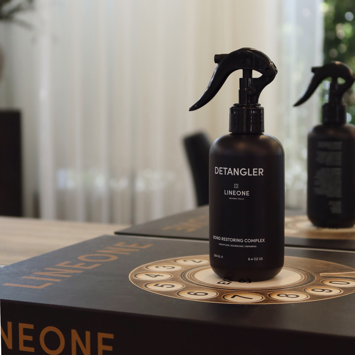 LINEONE Hair Weightless Detangler close-up on dark book cover with embossed LINEONE wordmark
