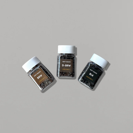 Three LINEONE Hair Micro Beads jars in Brown, Dark Brown and Black shades arranged on grey background