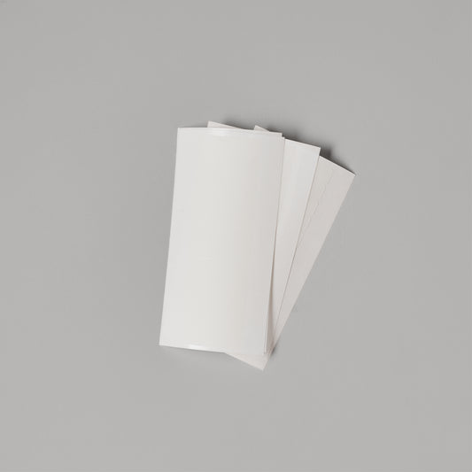 LINEONE Hair Single Sided Tape Backings fanned stack of white adhesive strips on grey background