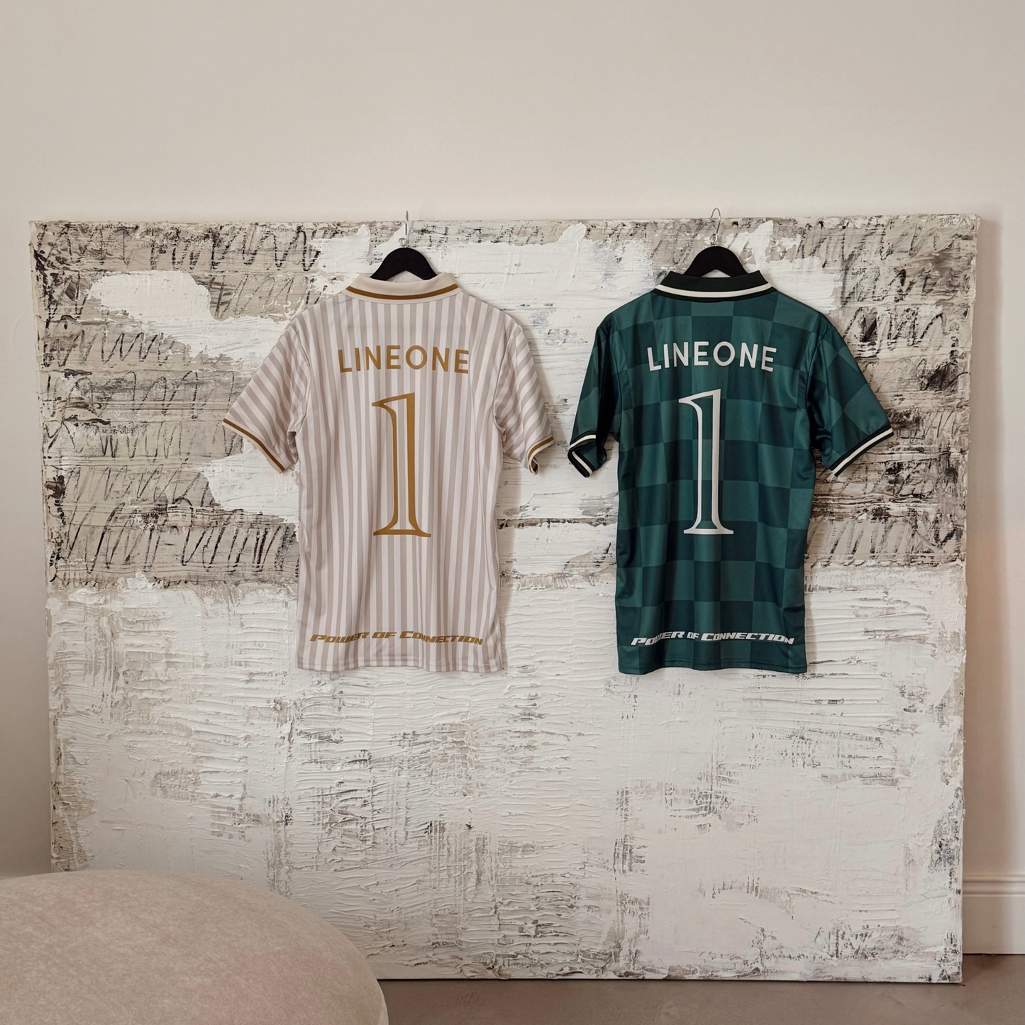 Framed LINEONE Hair Team Works Jersey cream away and green home kits displayed on whitewashed wall