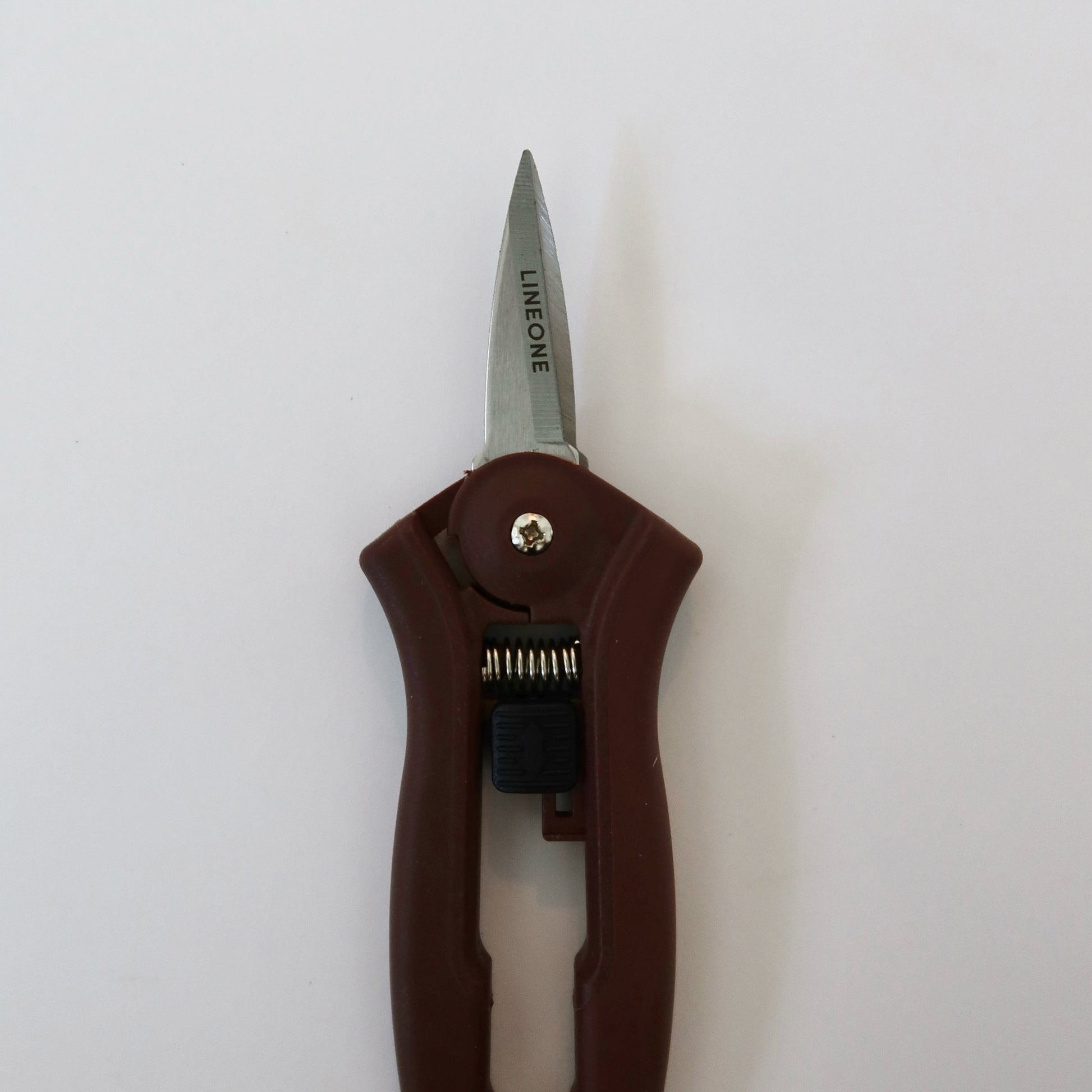 LINEONE Bond mini trimmer upright front view showing stainless steel blade and dark brown ergonomic handle on white background