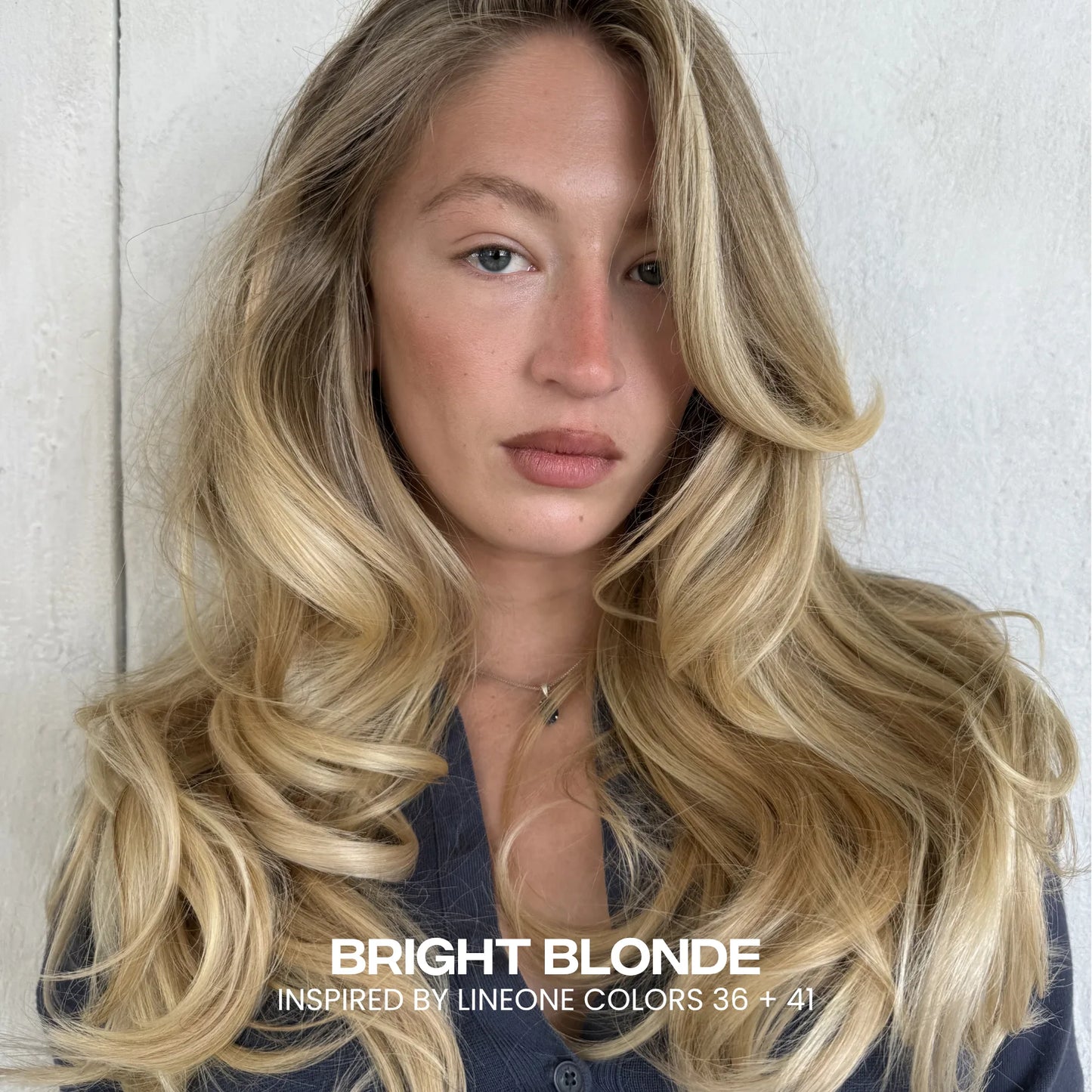 Close-up of model wearing LINEONE Hair Bright Blonde clip-ins, long voluminous warm blonde curls and middle part