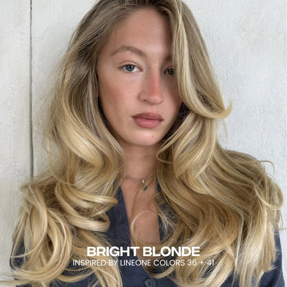 Close-up of model wearing LINEONE Hair Bright Blonde clip-ins, long voluminous warm blonde curls and middle part