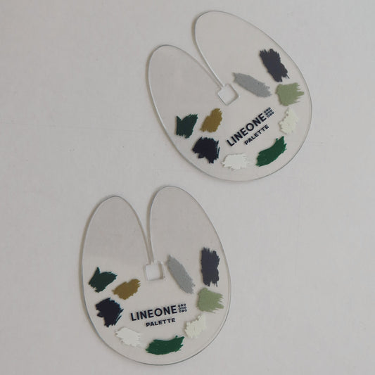 Two LINEONE Hair Keratin Heat Shield palettes shaped like teardrops with painted color swatches on white