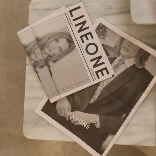 Two LINEONE Hair Newsprint SS2026 Vol III issues fanned on a marble table with editorial covers visible