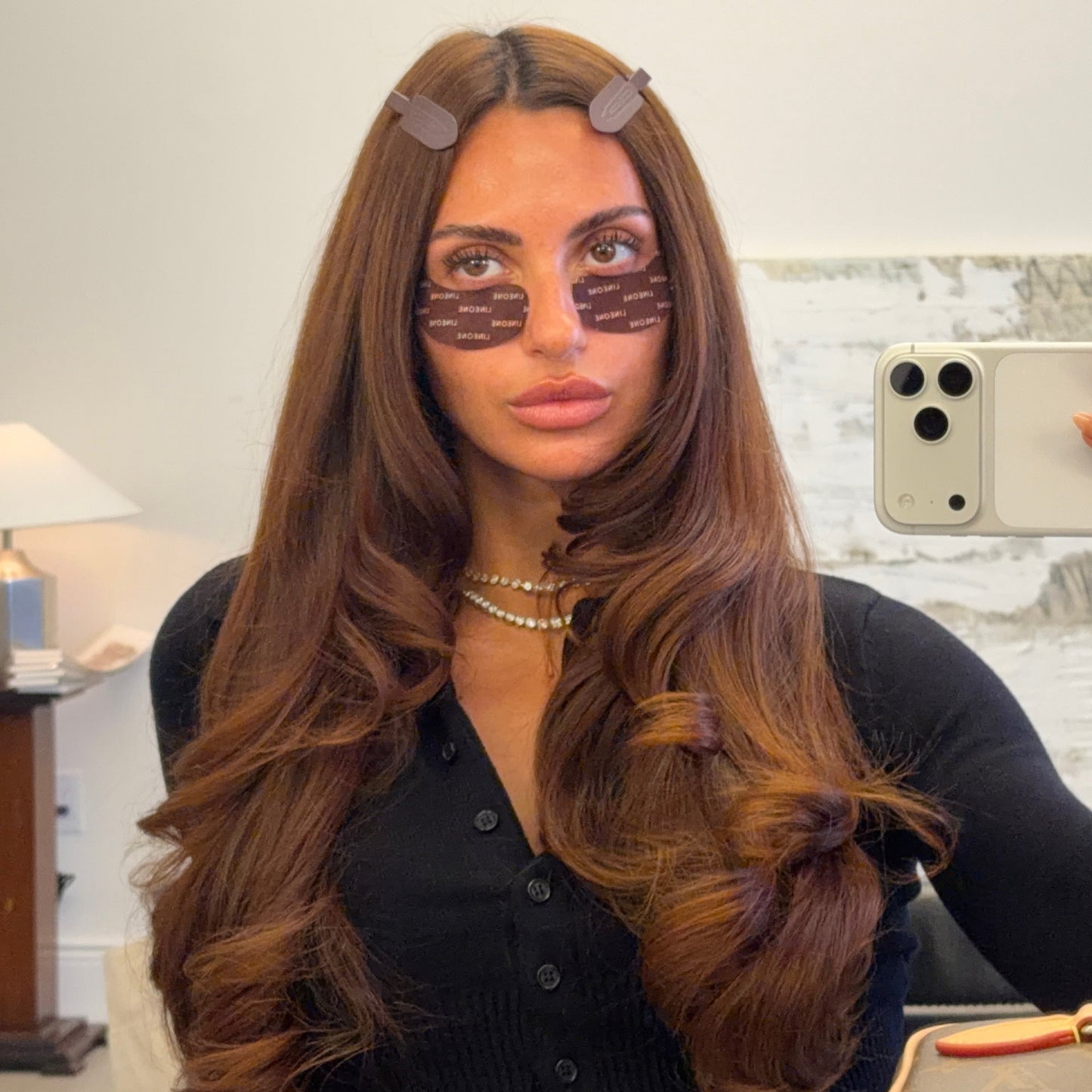 Brunette model in mirror selfie wearing brown LINEONE Hair Please Hold Clips with under-eye masks