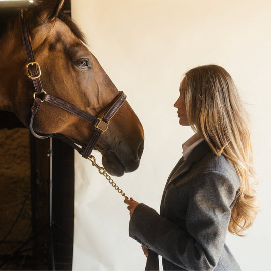 Blonde stylist in grey blazer leading a chestnut horse by the halter, LINEONE Hair Keratin Intro Kit Dimensional Brunette