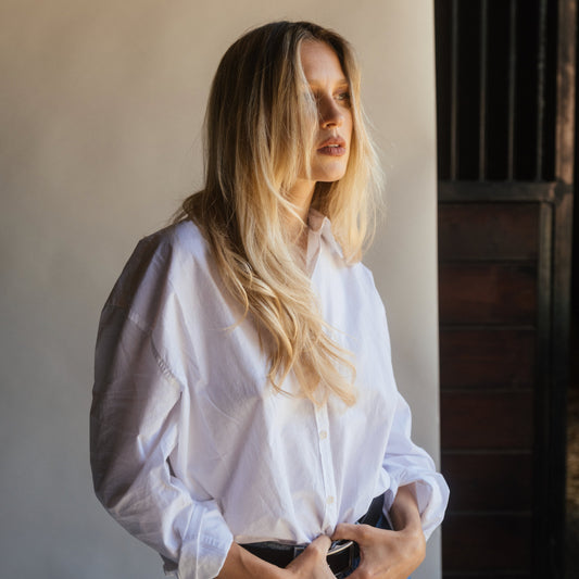 Rooted blonde waves on a model in oversized white shirt by a stable door, LINEONE Hair Keratin Intro Kit Blonde