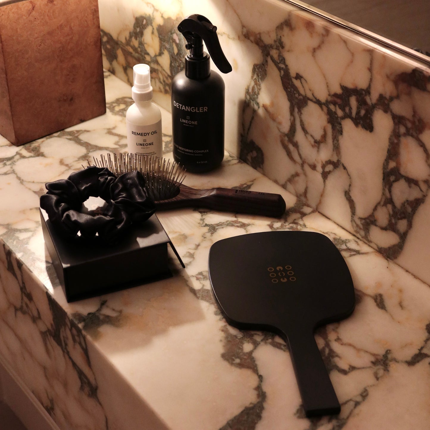 LINEONE Hair Mirror styled on Calacatta marble with Remedy Oil, Detangler, brush and silk scrunchie