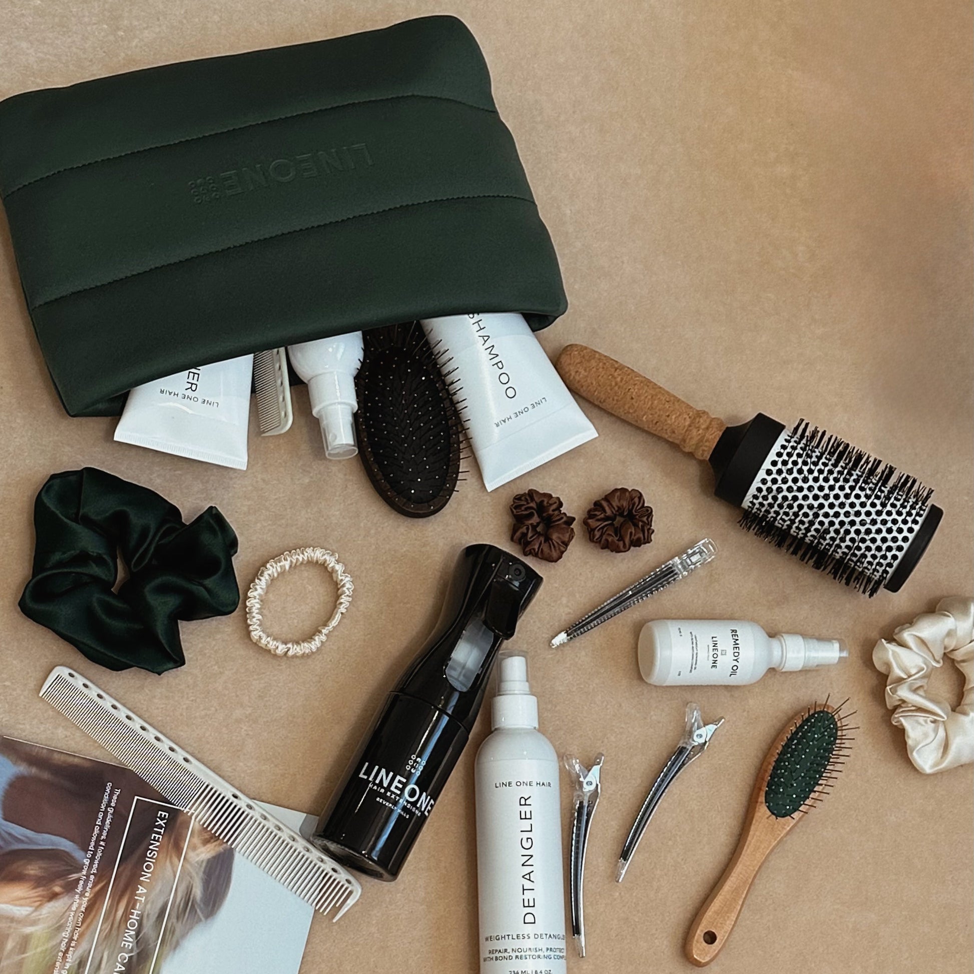LINEONE Hair The Carry On hunter green pouch overflowing with full Aftercare Ritual Kit flat-lay
