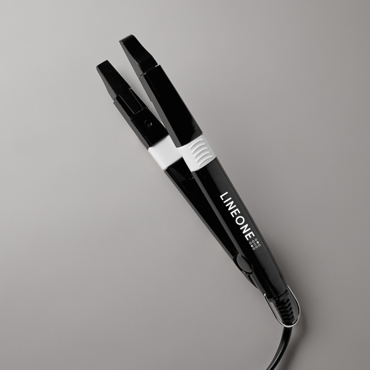 LINEONE Hair Keratin Bond Application Tool with sleek black handle and silver hinged tip on grey background