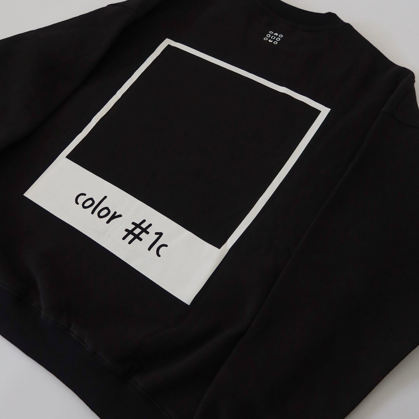 Back of black LINEONE Hair Pantone Crewneck showing white polaroid frame around color #1c square