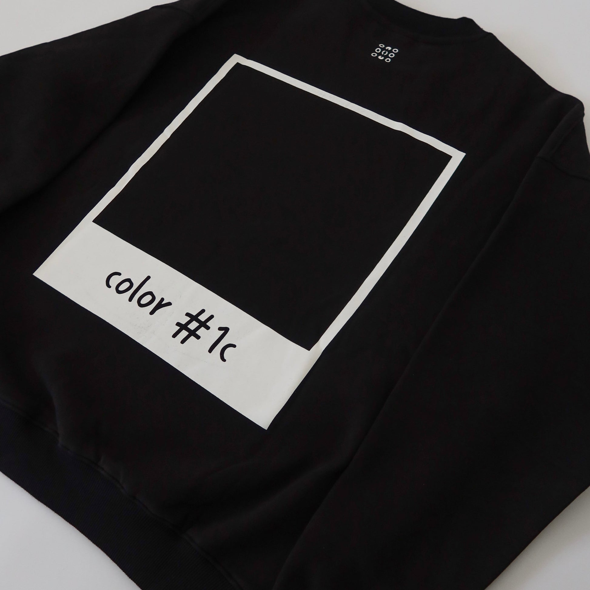 Back of black LINEONE Hair Pantone Crewneck showing white polaroid frame around color #1c square
