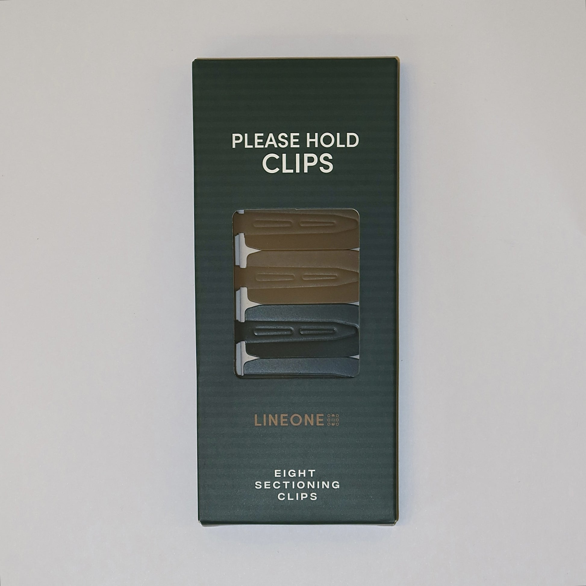 LINEONE Hair Please Hold Clips boxed packaging, hunter green with cutaway window showing eight sectioning clips