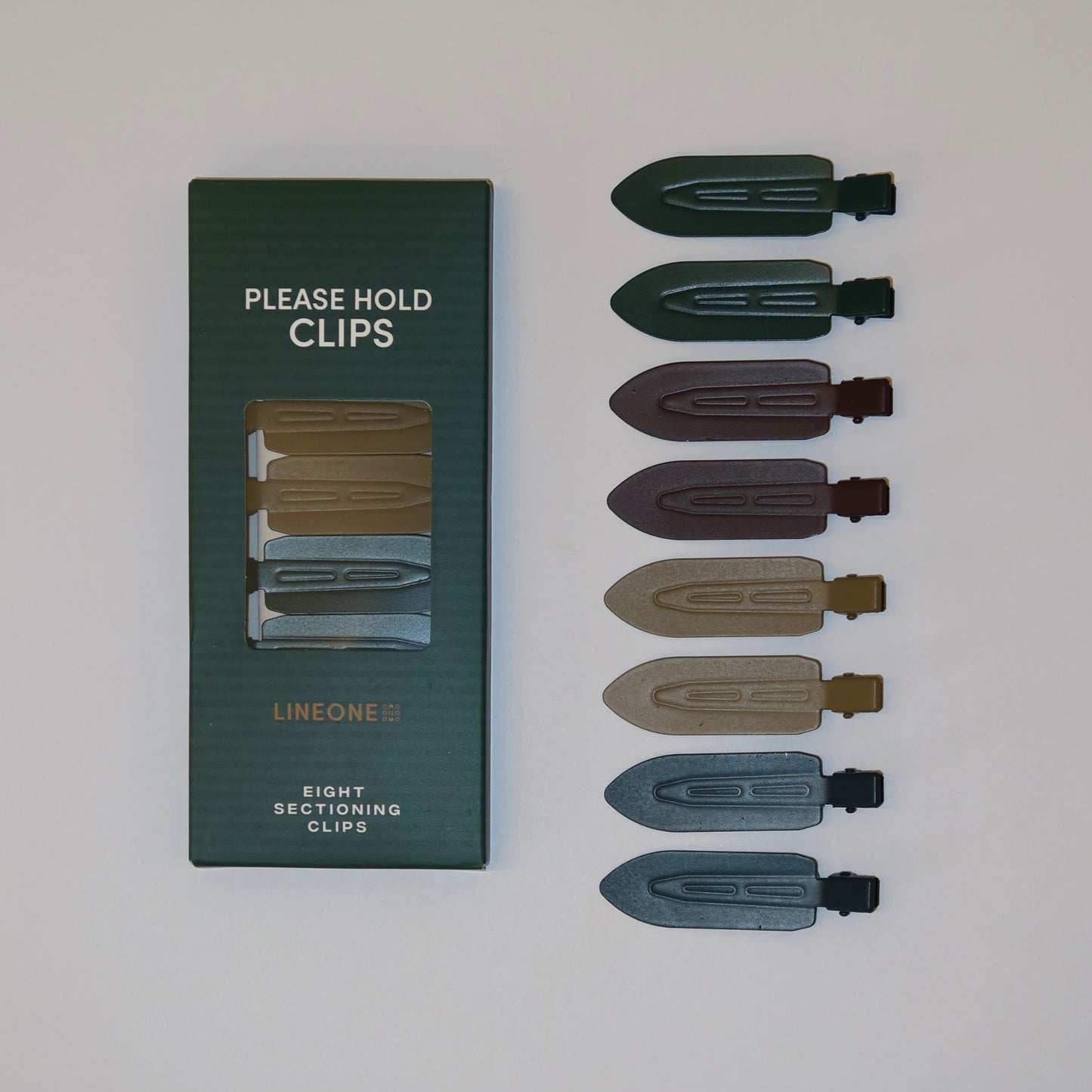 LINEONE Hair Please Hold Clips green packaging next to all eight clips in green, plum, sand and slate