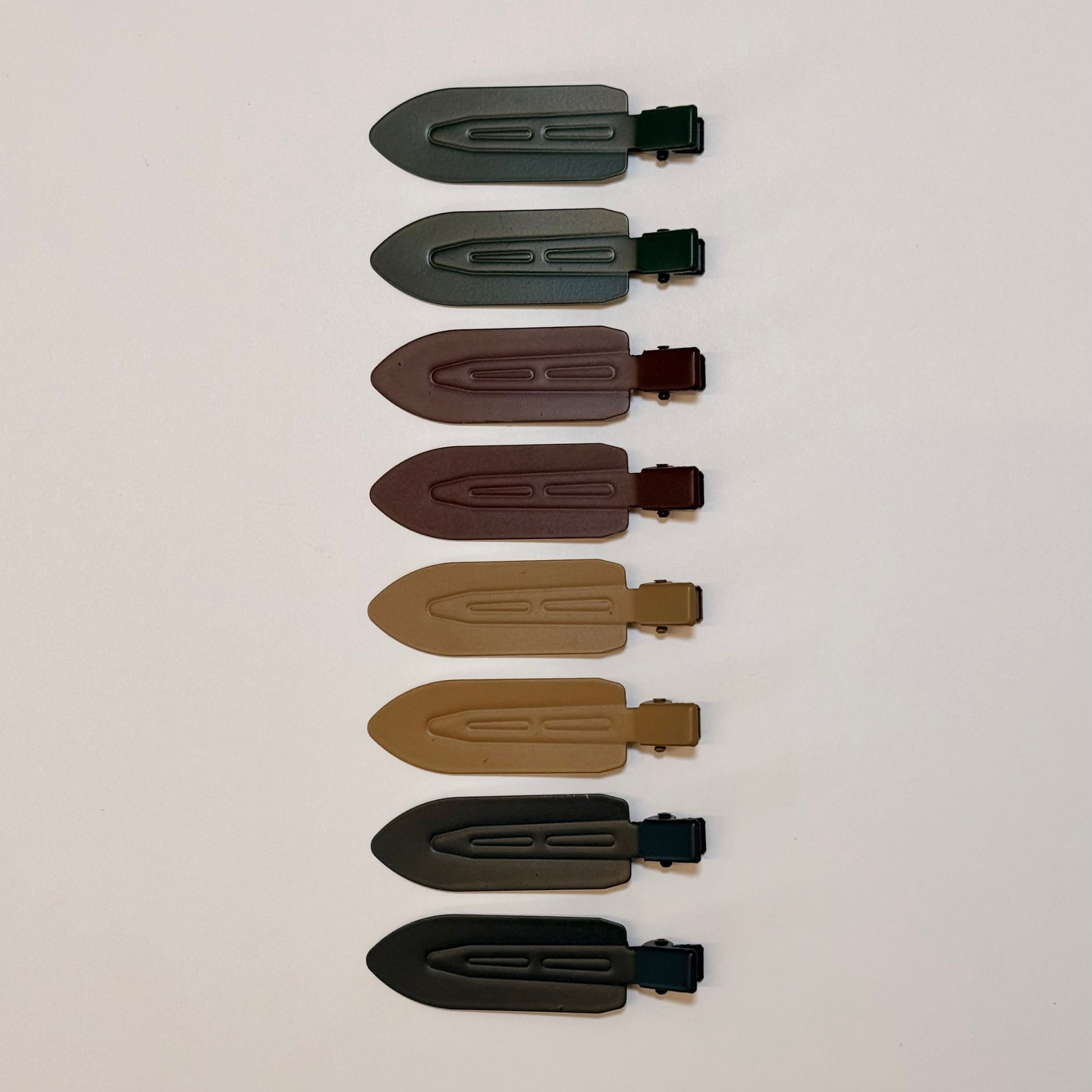 All eight LINEONE Hair Please Hold Clips arranged vertically in green, plum, sand and slate tones