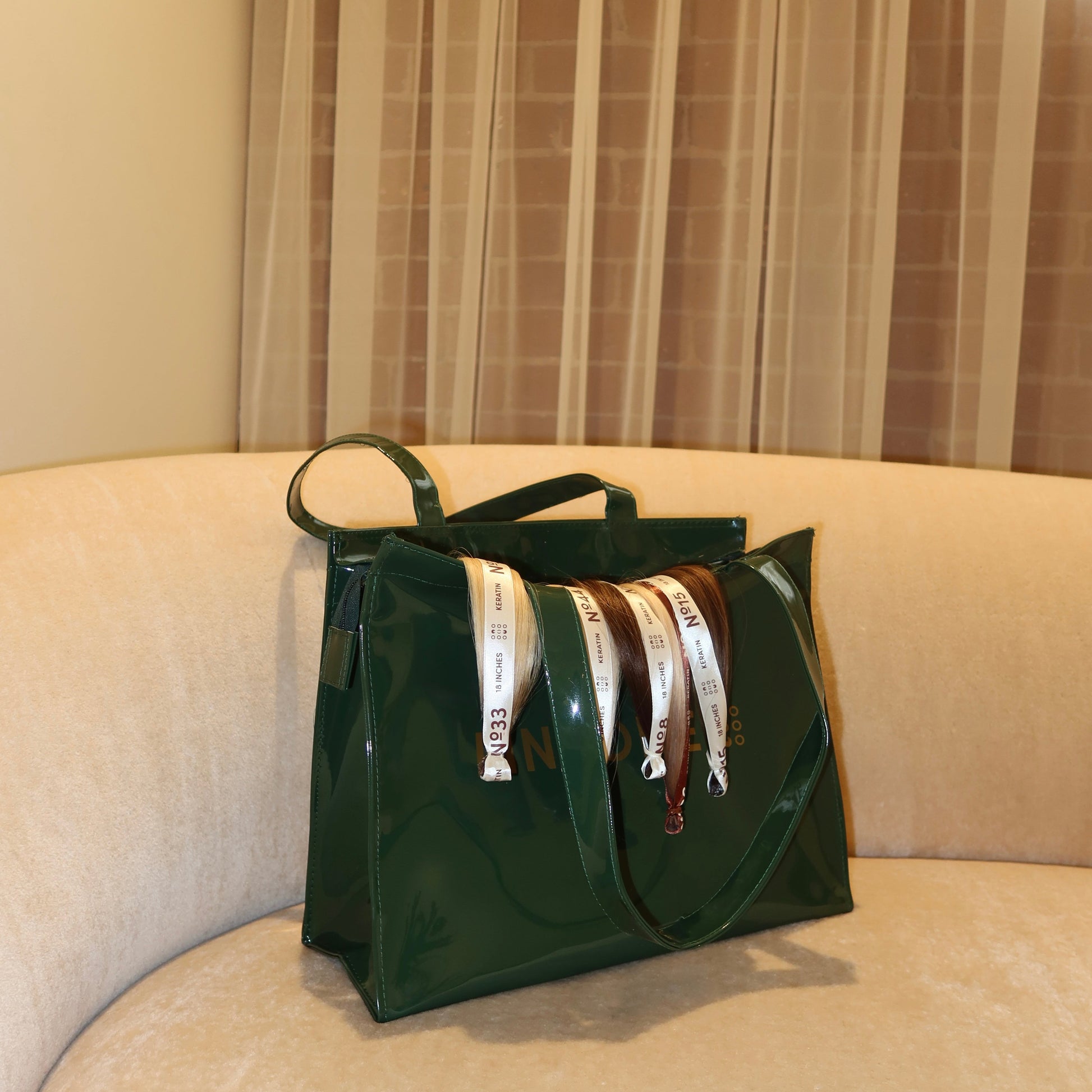 Side view of LINEONE Hair Rodeo Bag stuffed with rolled extension bundles on a beige curved sofa