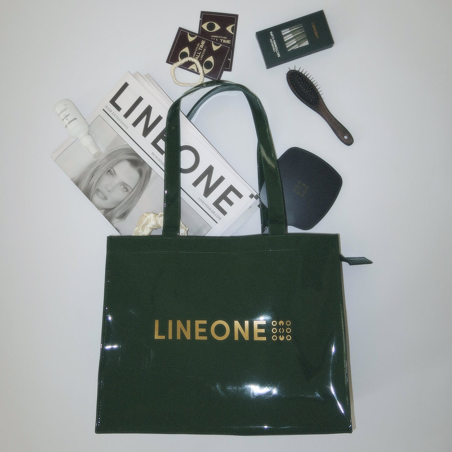 LINEONE Hair Rodeo Bag flat lay with Newsprint, brush, Mirror, clip pack and scrunchie on white